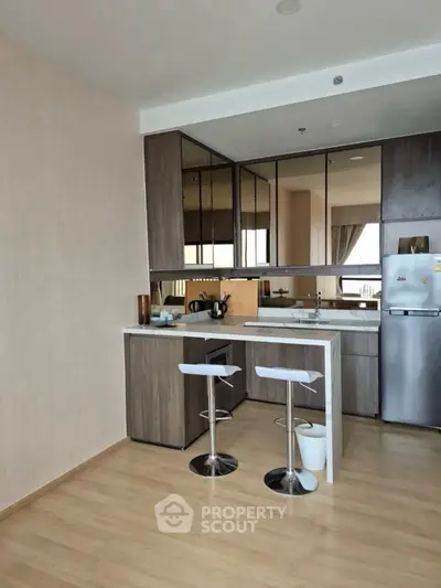 Modern kitchen with sleek cabinets and breakfast bar in stylish apartment.