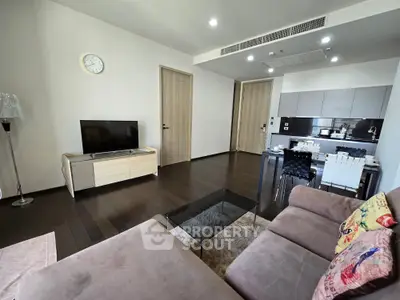 Modern living room with sleek kitchen, stylish furniture, and elegant decor in a contemporary apartment.