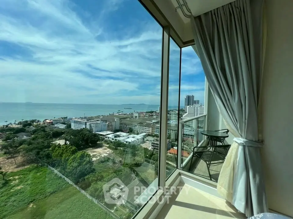 Stunning high-rise balcony view overlooking the ocean and cityscape, perfect for relaxation.
