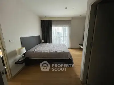 Spacious bedroom with modern decor and large window for natural light