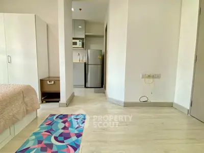 Modern studio apartment with compact kitchen and cozy sleeping area.