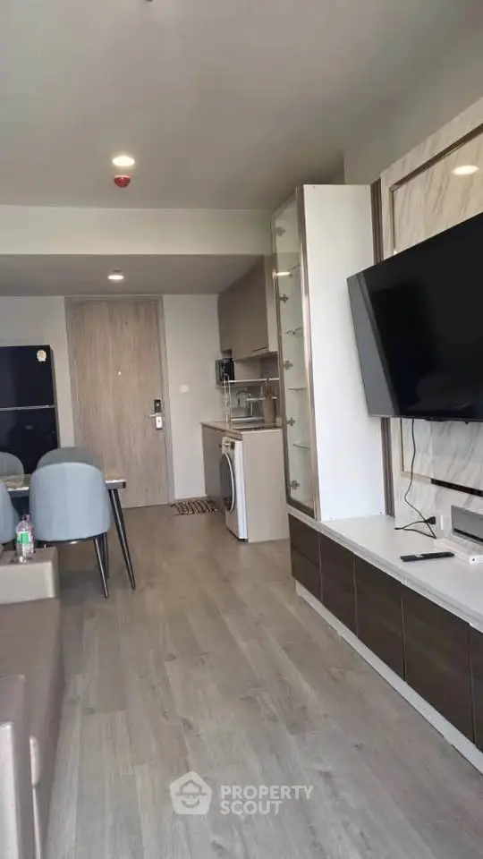 Modern living room with sleek furniture and wall-mounted TV in a stylish apartment.