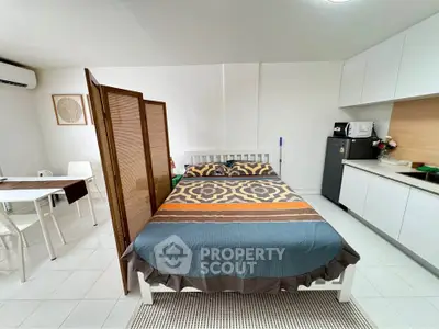Cozy studio apartment with modern furnishings and compact kitchen area.