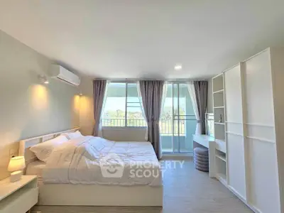 Bright and airy bedroom with balcony access and modern furnishings.