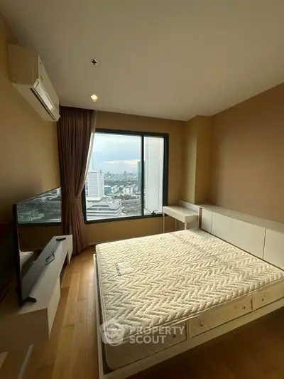 Spacious bedroom with city view, featuring a large window and modern furnishings, ideal for urban living.
