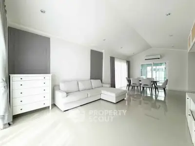 Spacious modern living room with sleek white furniture and abundant natural light