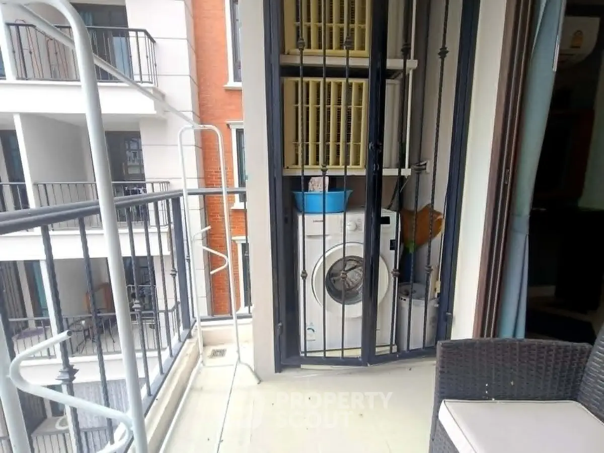 Modern balcony with washing machine and outdoor seating in urban apartment