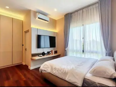 Modern bedroom with large window, stylish decor, and wooden flooring