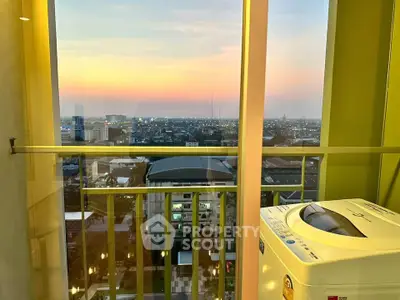 Stunning high-rise apartment view with sunset and washing machine on balcony.