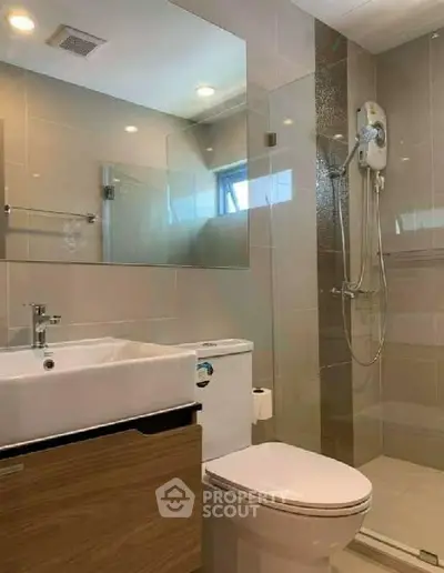 Modern bathroom with glass shower and sleek fixtures in a contemporary apartment.