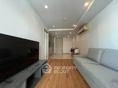 Spacious modern living room with sleek wooden flooring and contemporary furniture.