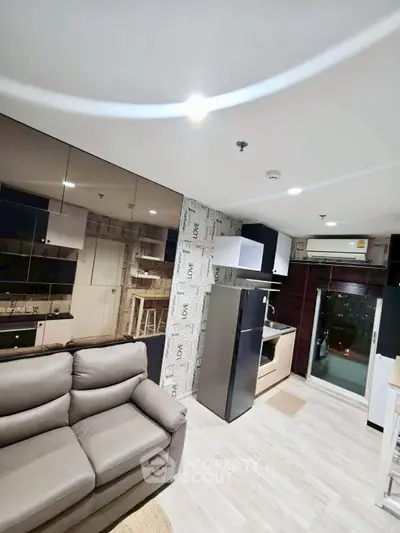 Modern living room with sleek kitchen and balcony access in stylish apartment.