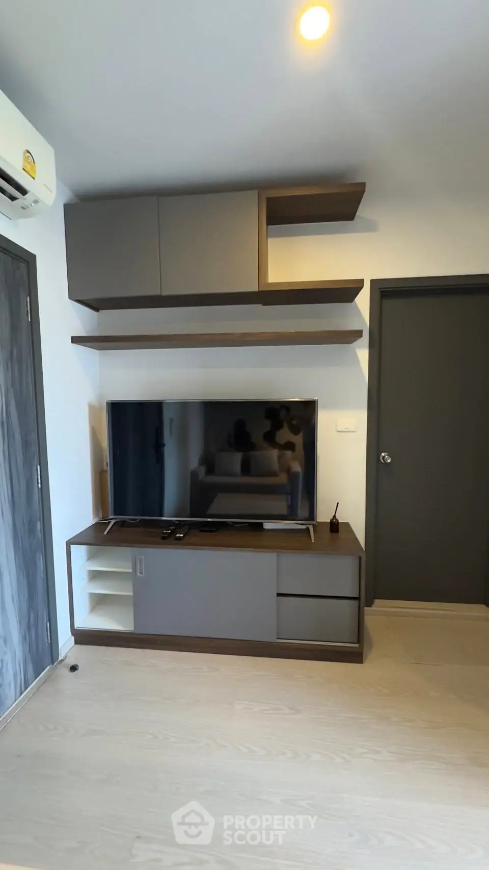 Modern living room with sleek TV unit and floating shelves, perfect for stylish urban living.