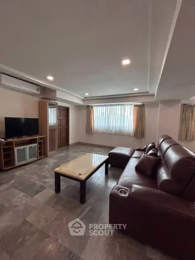 Spacious living room with leather sofa and modern entertainment center