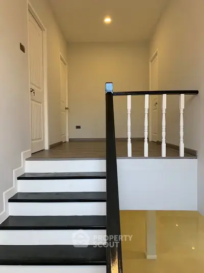 Modern staircase with sleek black and white design in a contemporary home interior.
