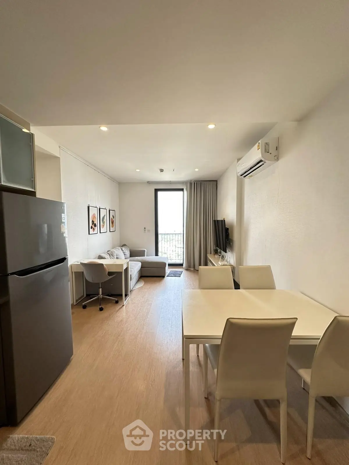 Modern open-plan living room with dining area and balcony access in a stylish apartment.