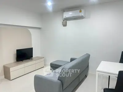 Modern living room with sleek furniture and wall-mounted air conditioner