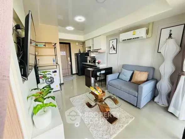 Modern living room with stylish decor, compact kitchen, and cozy seating area in a contemporary apartment.