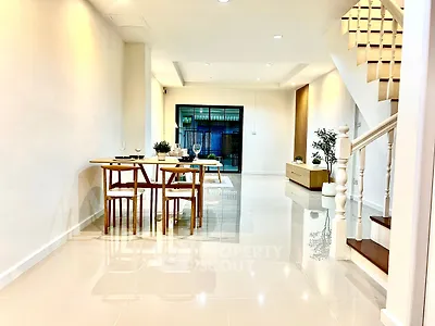 Spacious modern living room with elegant dining area and staircase
