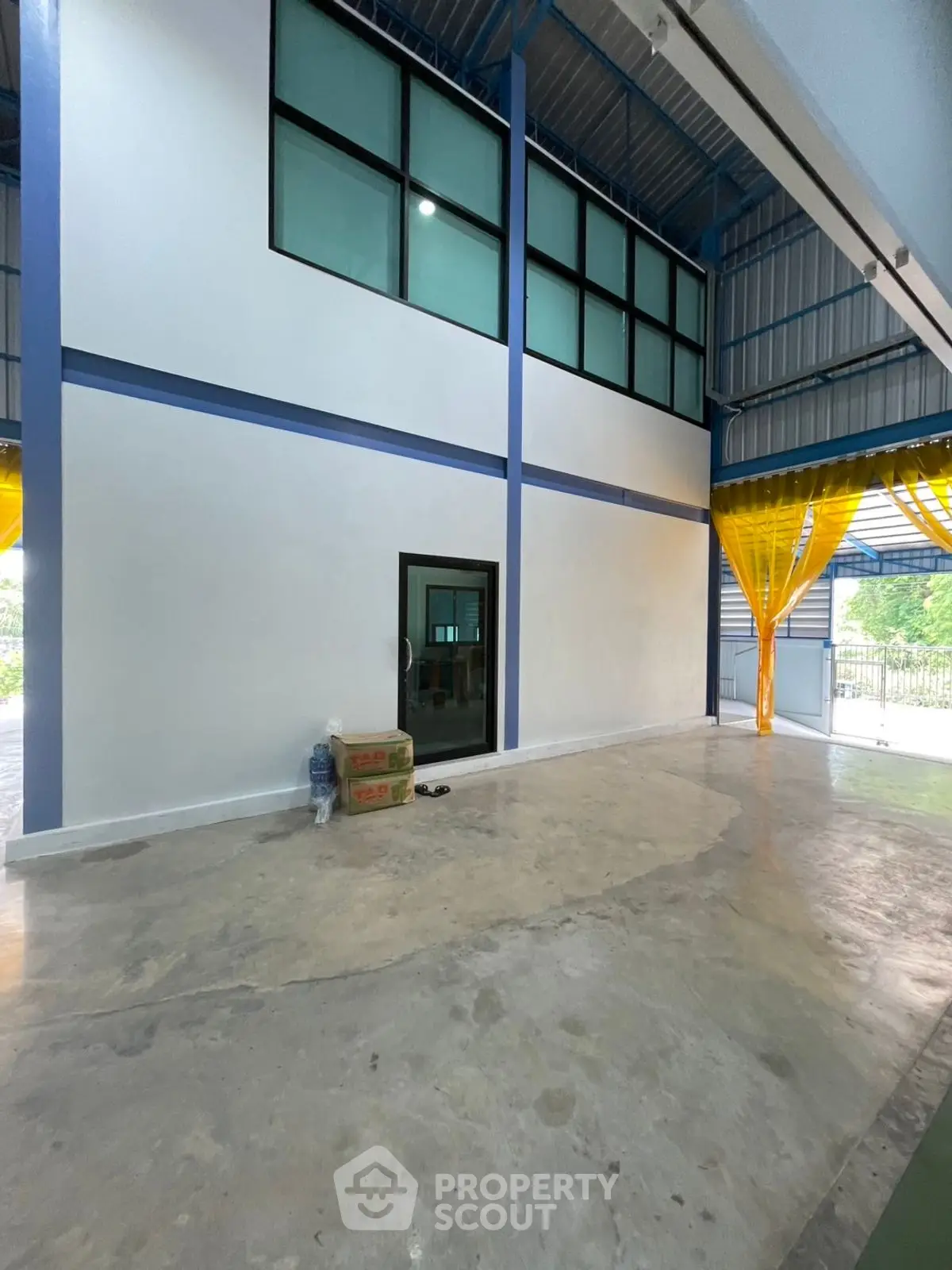 Spacious industrial warehouse with high ceilings and large windows, perfect for storage or manufacturing needs.