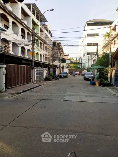 Charming urban street view with residential buildings and parked cars, ideal for city living.
