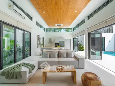 Luxurious open-plan living room with modern decor and pool view, perfect for relaxation and entertaining.