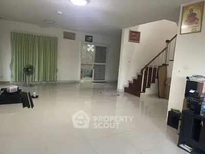 Spacious living room with tiled floor and staircase in modern home