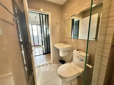 Modern bathroom with sleek fixtures and glass shower in contemporary apartment.