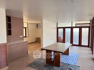 Spacious open-plan living area with modern wooden finishes and large windows.