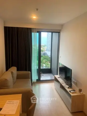 Modern living room with balcony and ocean view in a high-rise apartment.