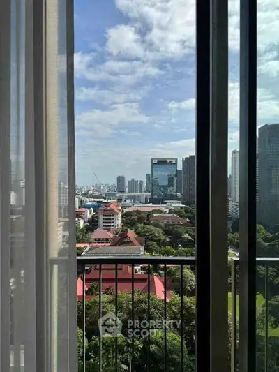 Stunning cityscape view from a high-rise balcony with lush greenery and skyline.