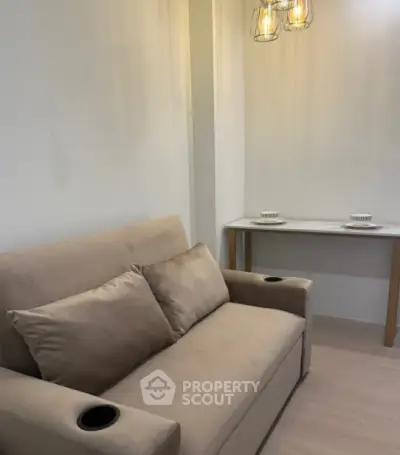 Cozy living room with beige sofa and modern lighting, perfect for relaxation.
