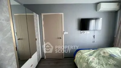 Modern bedroom with wall-mounted TV and air conditioning, featuring stylish decor and ample storage space.