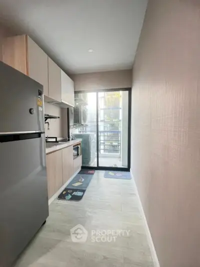 Modern kitchen with sleek appliances and balcony view, perfect for urban living.