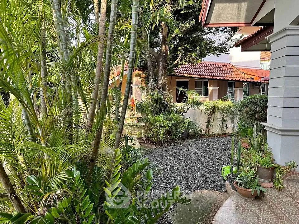 Charming garden view with lush greenery and cozy home exterior.