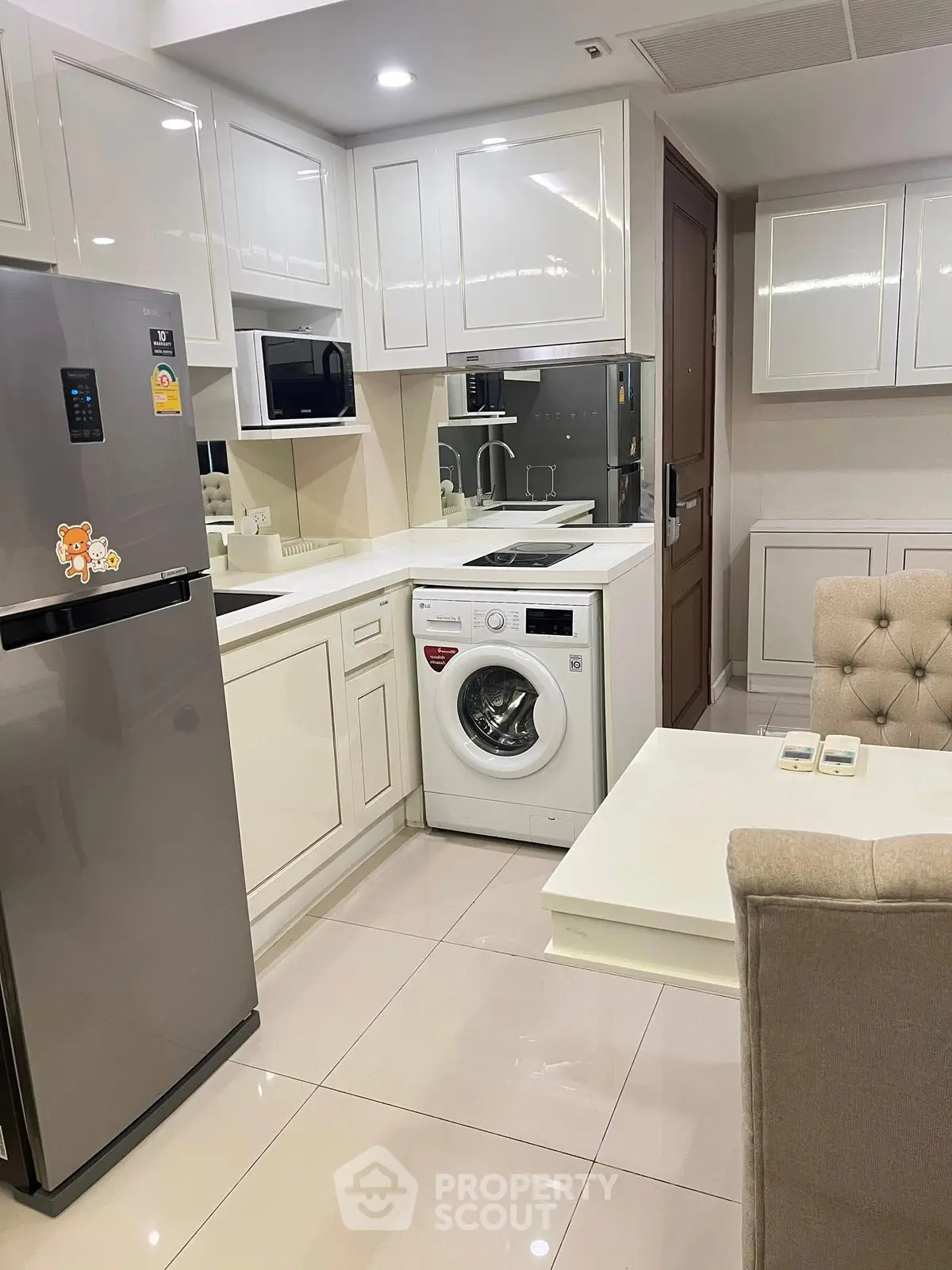 Modern kitchen with washing machine and sleek white cabinetry