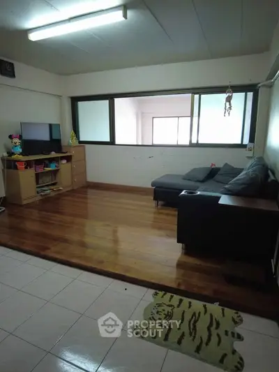 Cozy living room with wooden flooring and modern furniture, perfect for relaxation.