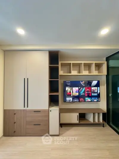 Modern living room with sleek built-in entertainment center and TV display.