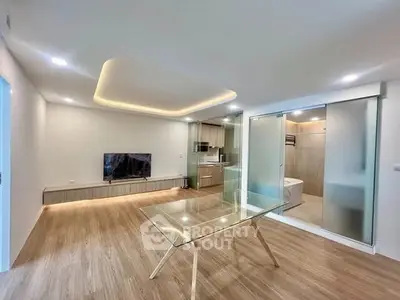 Modern open-plan living room with sleek kitchen and stylish lighting