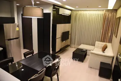 Modern living room with sleek furniture and open kitchen layout in a stylish apartment.