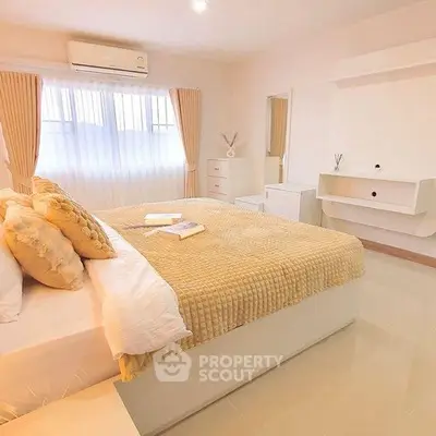 Spacious and bright bedroom with modern decor and ample natural light.