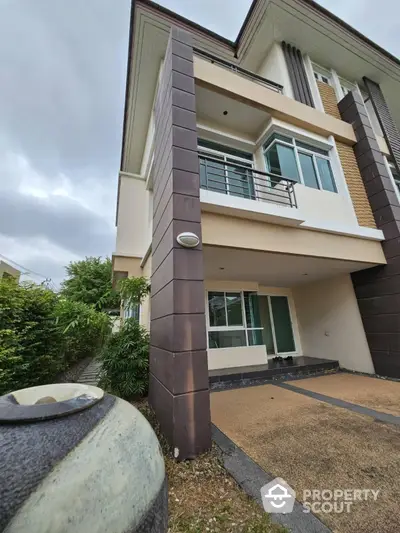 Modern multi-story house with spacious balcony and driveway