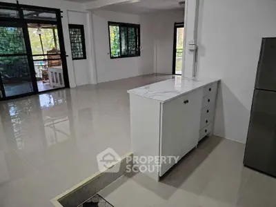 Spacious open-plan living area with modern cabinetry and large windows offering natural light.