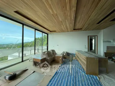 Spacious modern living room with large windows and scenic view under construction