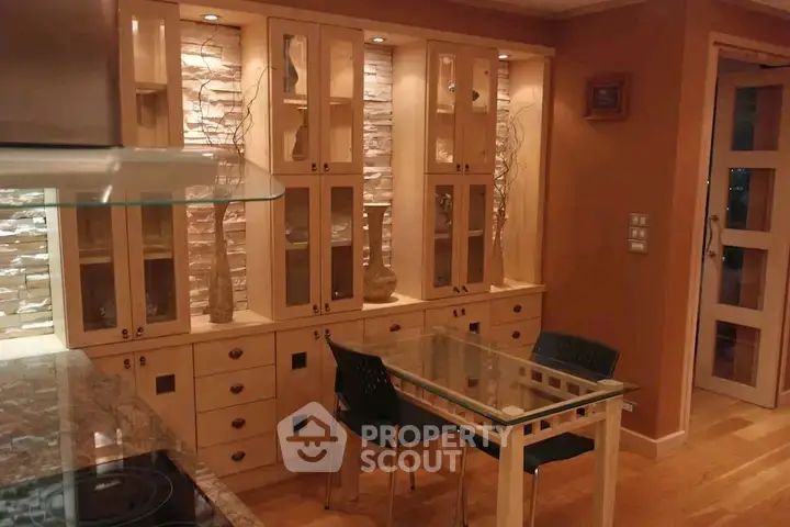 Elegant dining area with glass table and stylish cabinetry in modern home interior.