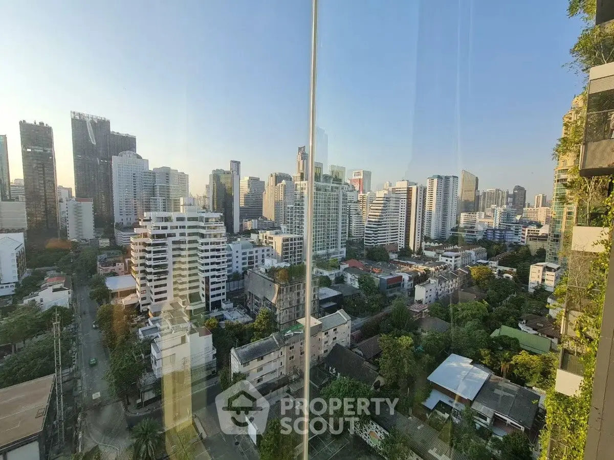 Stunning cityscape view from high-rise building with lush greenery and modern architecture.