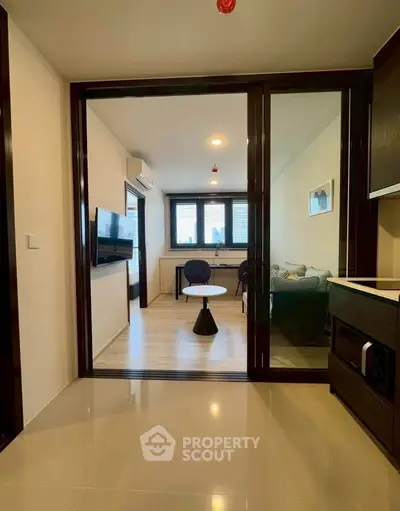 Modern living room with glass sliding doors and stylish furniture in a contemporary apartment.