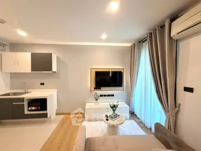 Modern living room with sleek kitchen, cozy sofa, and elegant decor in a stylish apartment.