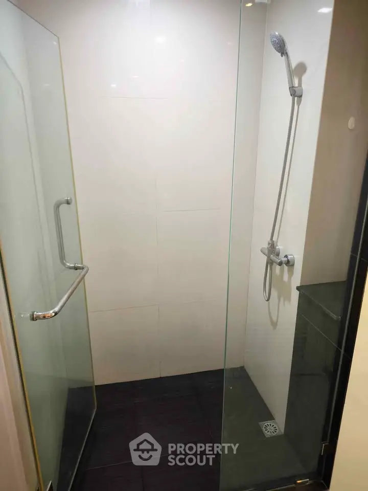 Modern shower area with glass enclosure and sleek fixtures in a contemporary bathroom.
