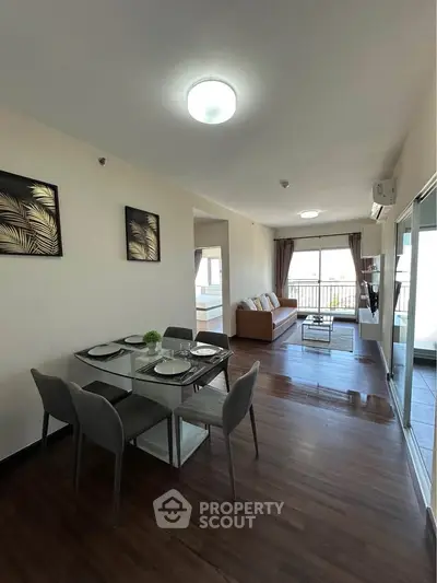 Modern open-plan living and dining area with stylish decor and balcony view.